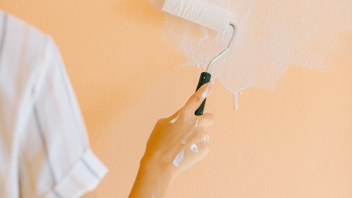 Painter rolling paint onto an interior wall