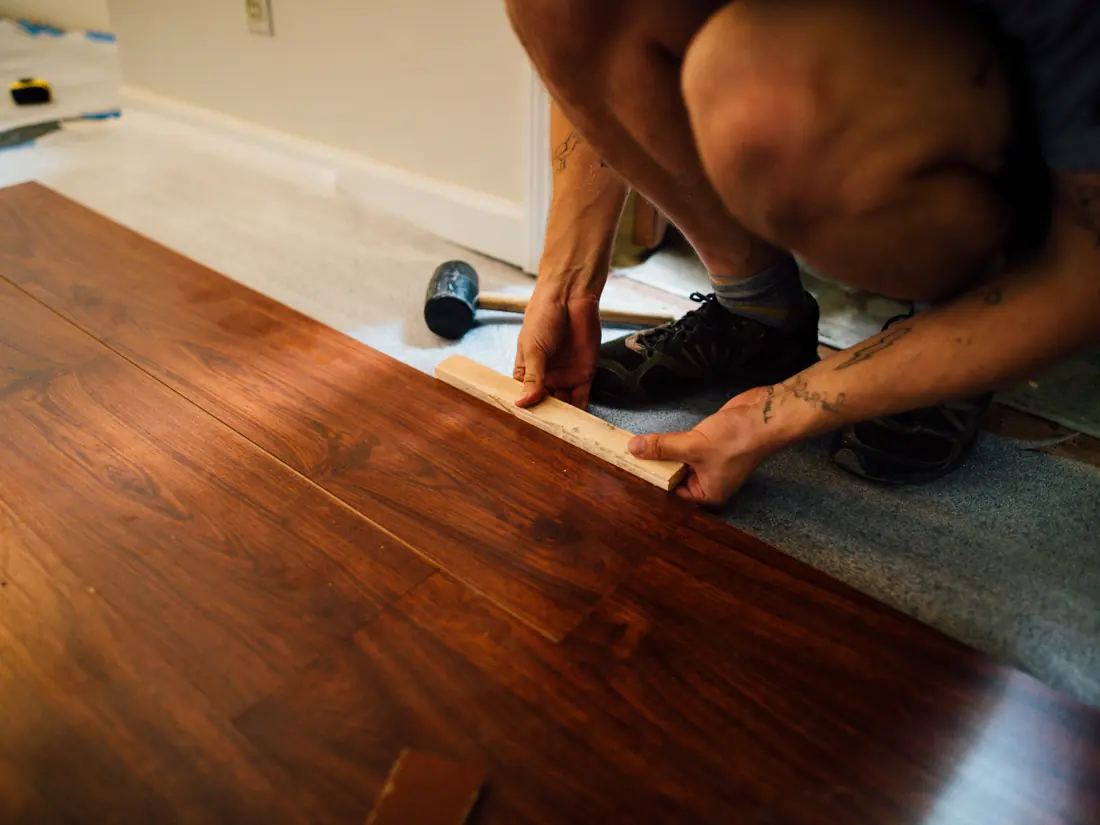 Flooring installer fitting a laminate board