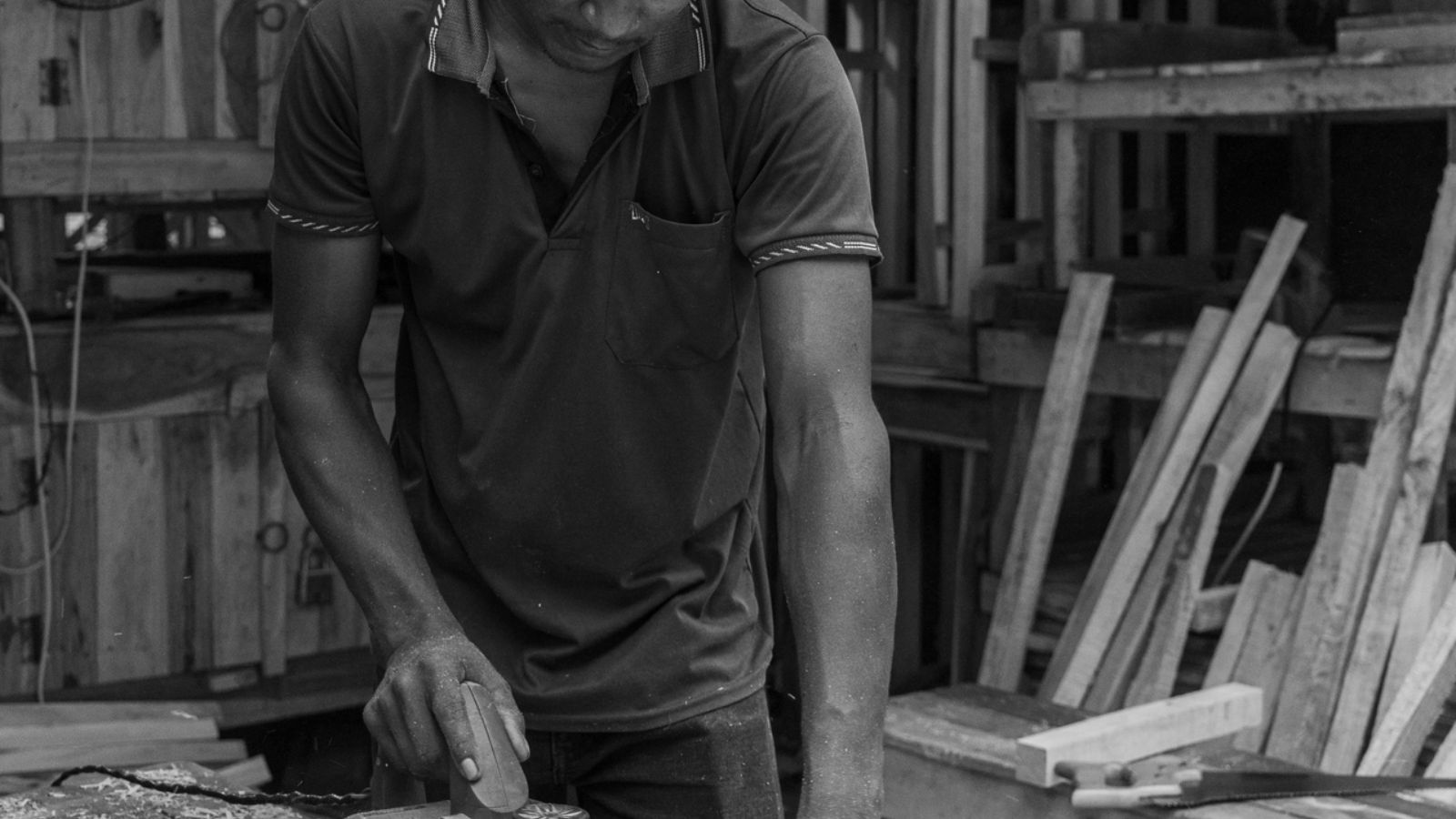 Carpenter shaping timber in a working woodshop.